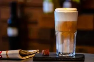 Caffe Julia Latte Macchiato mit Praline und Zeitung
